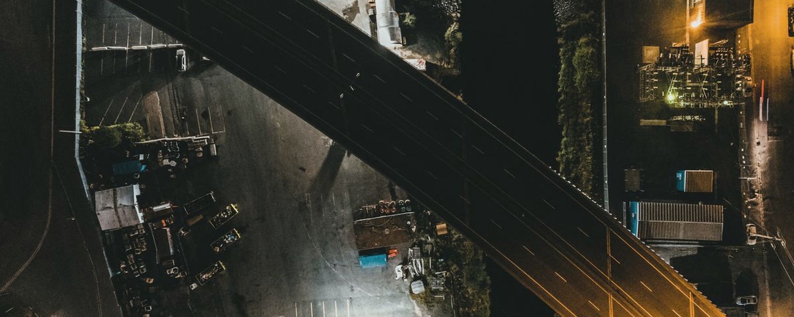 Aerial view of an elevated highway bridge crossing an industrial district at night