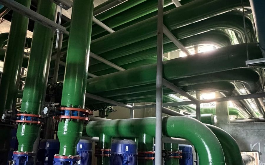 Pump sets and painted steel headers feeding the primary and secondary circuits