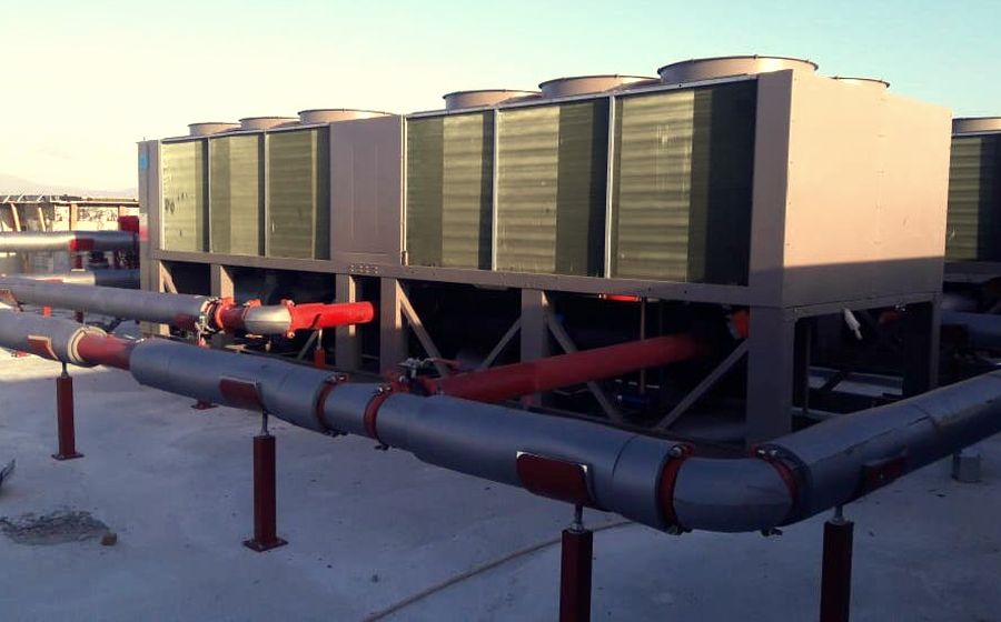 Bank of air-cooled chillers installed on a roof slab with insulated primary pipework